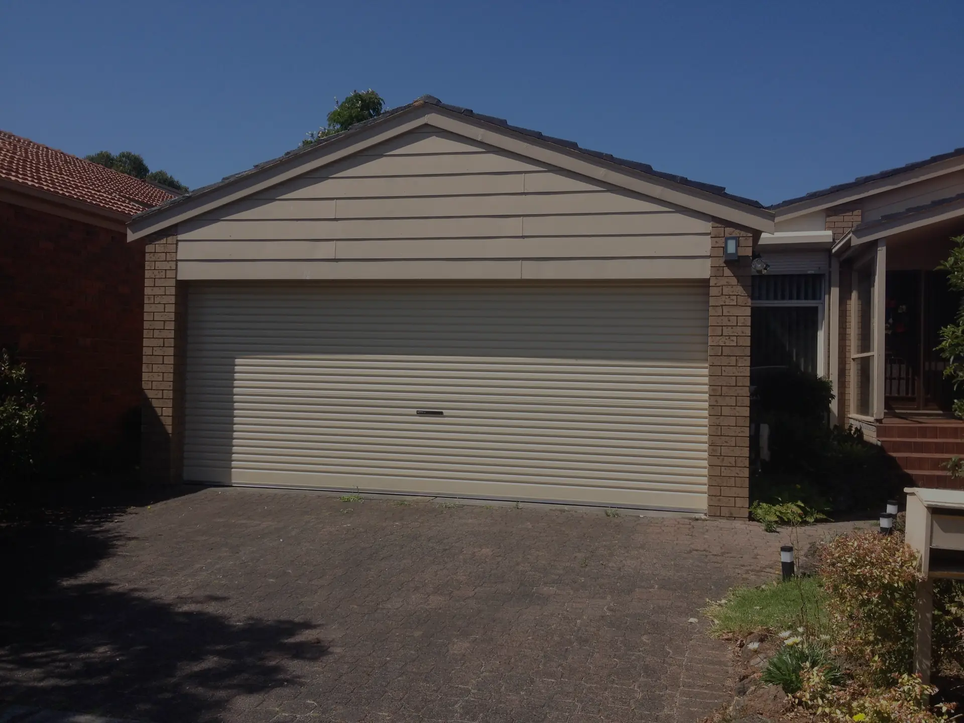 Cream roller garage door on a brick home